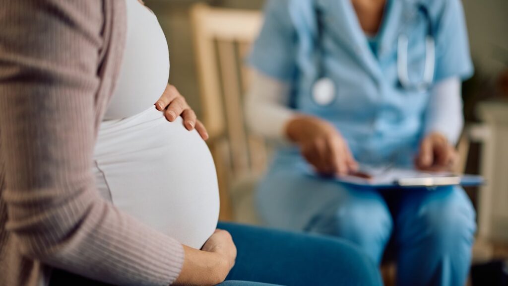Gravidă așezată, în timpul unei consultații cu asistenta medicală