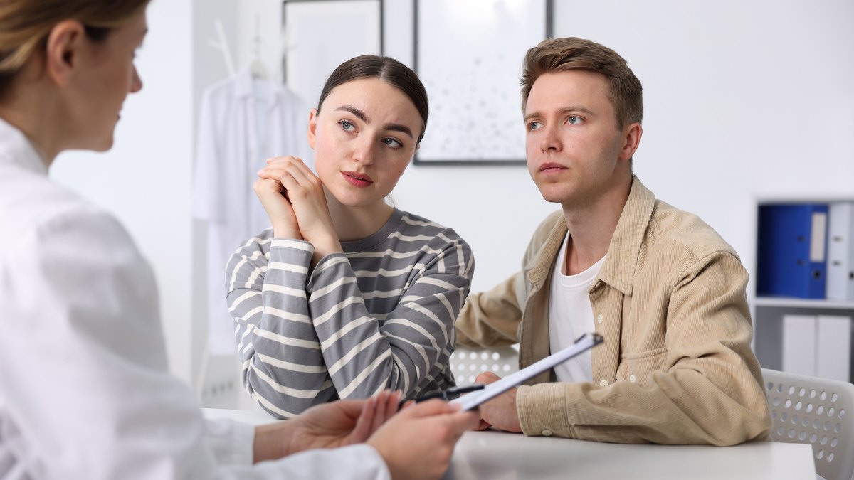 Cuplu la o consultație de fertilitate, împreună cu medicul specialist